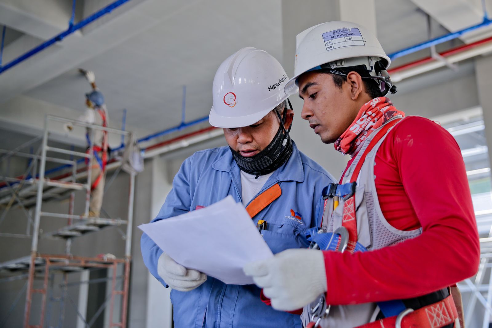 Indian site workers in safety kit reviewing a plan — Jaipur-style employment discipline for India-based gulf staffing
